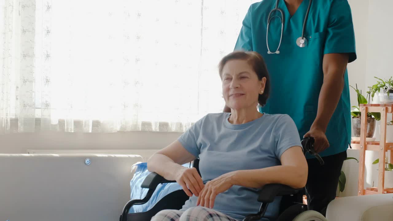 男护士在养老院帮助坐轮椅的老人视频素材