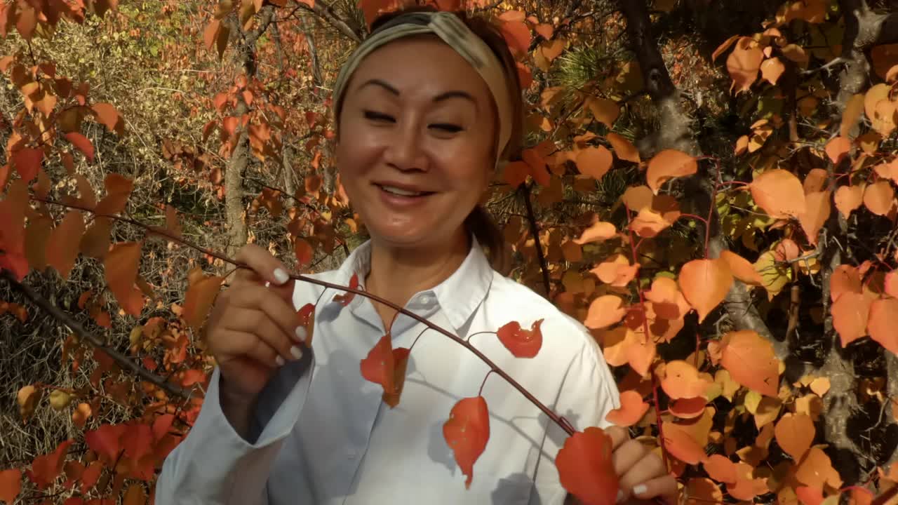 一个女人在秋天的树林里。视频下载