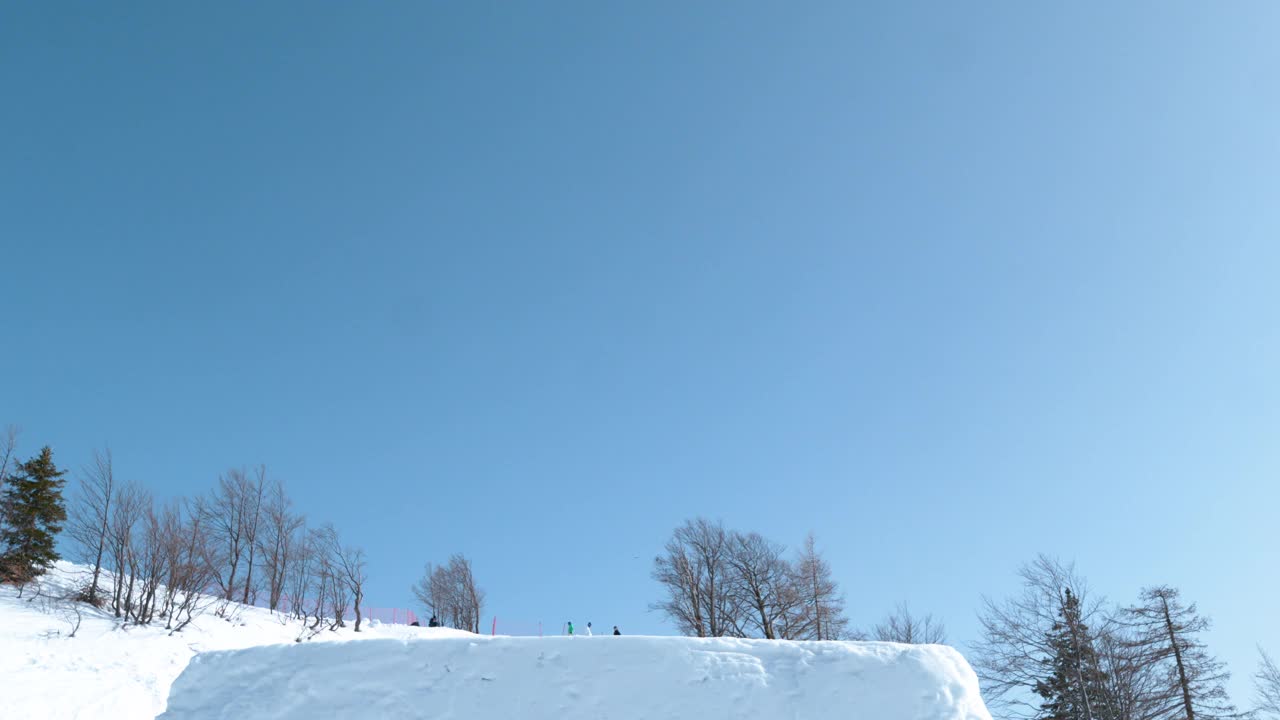 慢镜头:斯洛文尼亚滑雪男游客做了一个壮观的后空翻。视频素材