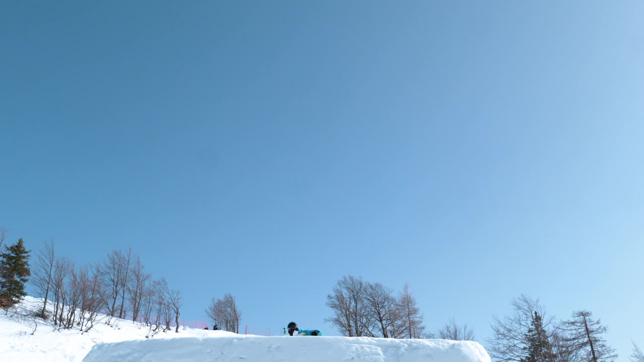 慢动作:滑雪者从踢脚者身上跳下来，做一个杂技的翻转动作。视频素材