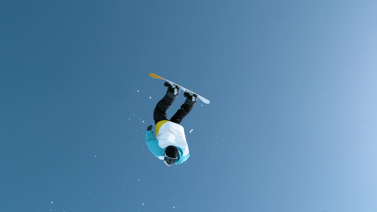 慢动作:滑雪者在从一个巨大的踢腿上跳下来后做一个后空翻。视频素材
