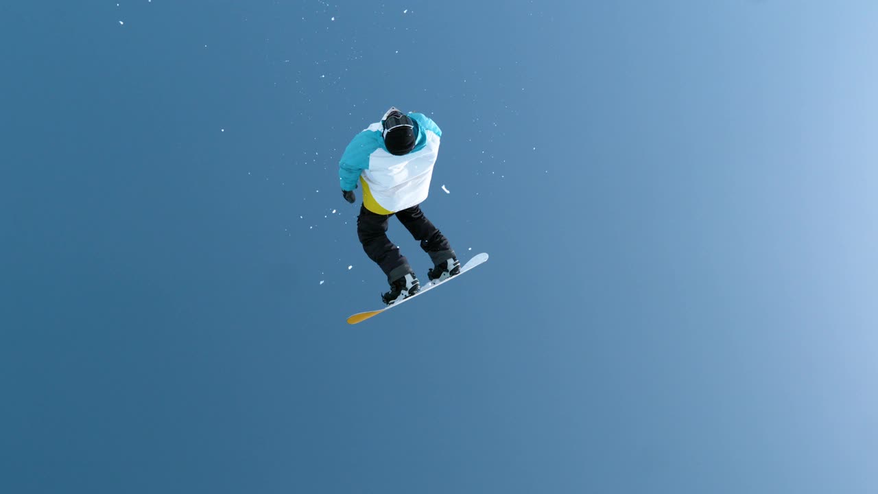 慢镜头:在中国山区滑雪的运动游客做一个翻转。视频素材