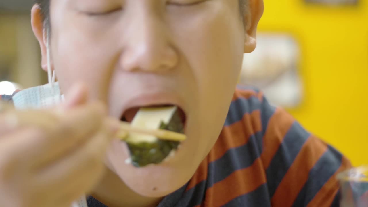 快乐的亚洲男孩和家人一起在日本餐厅享受美食，生活理念。视频素材