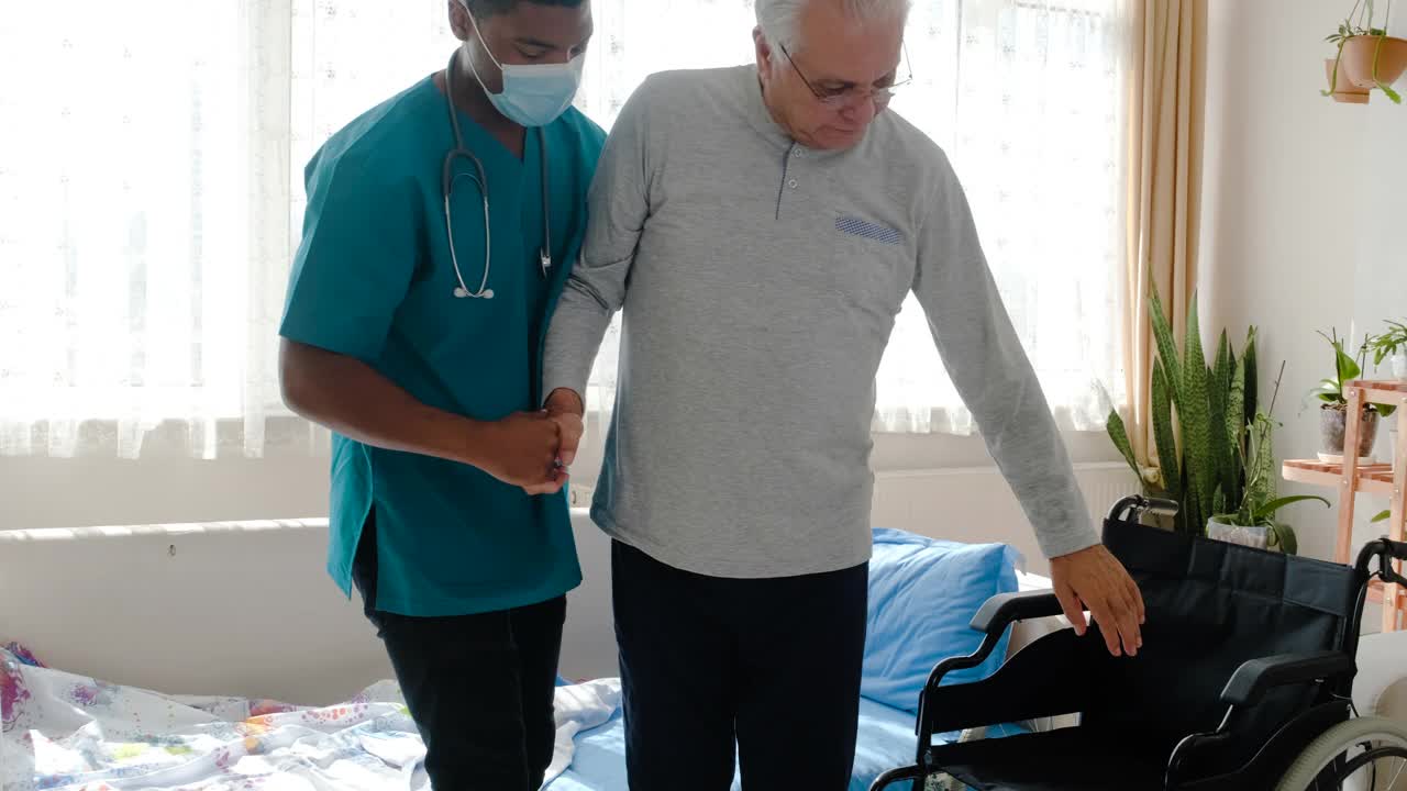 男护士在养老院帮助坐轮椅的老人视频素材