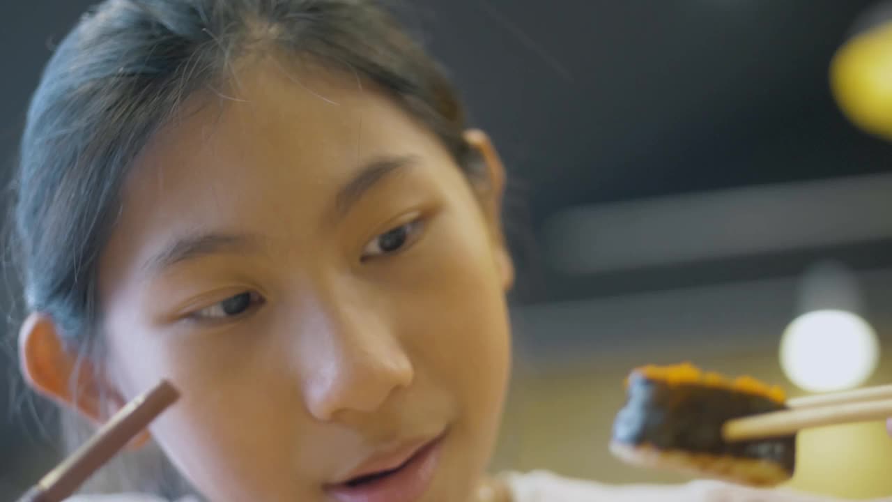 快乐的亚洲女孩和家人一起在日本餐厅享受美食，生活理念。视频下载