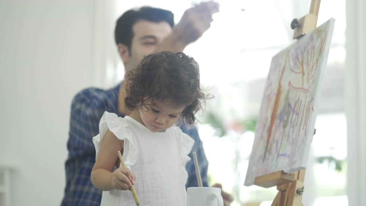 4K父亲和小女孩在艺术家的画布上作画视频下载