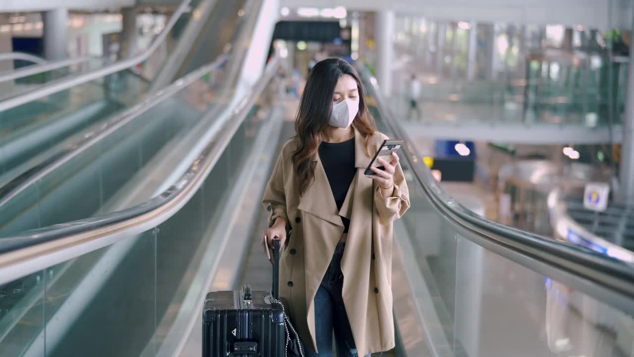 旅客佩戴外科口罩，用智能手机查看登机牌。视频下载