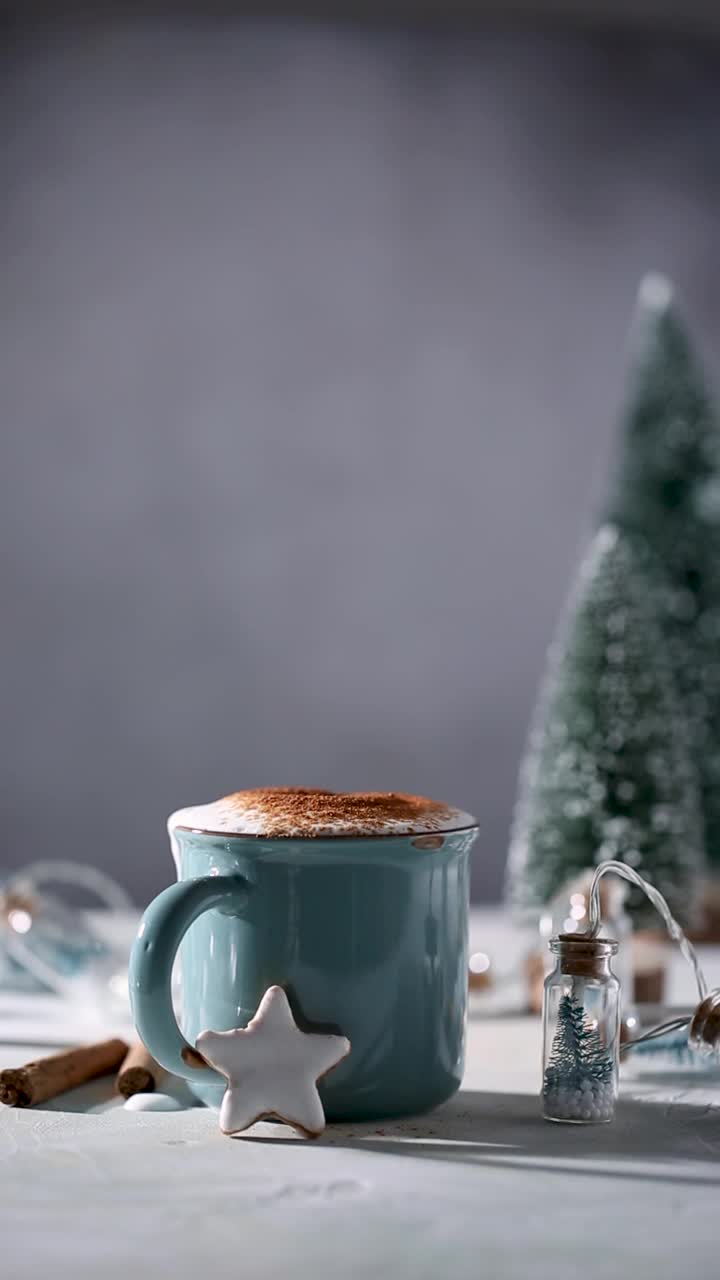 圣诞节喝。在蓝杯的热巧克力中撒上棉花糖，在白釉和装饰的姜饼星形饼干中点缀。全高清25 fps垂直视频素材视频素材