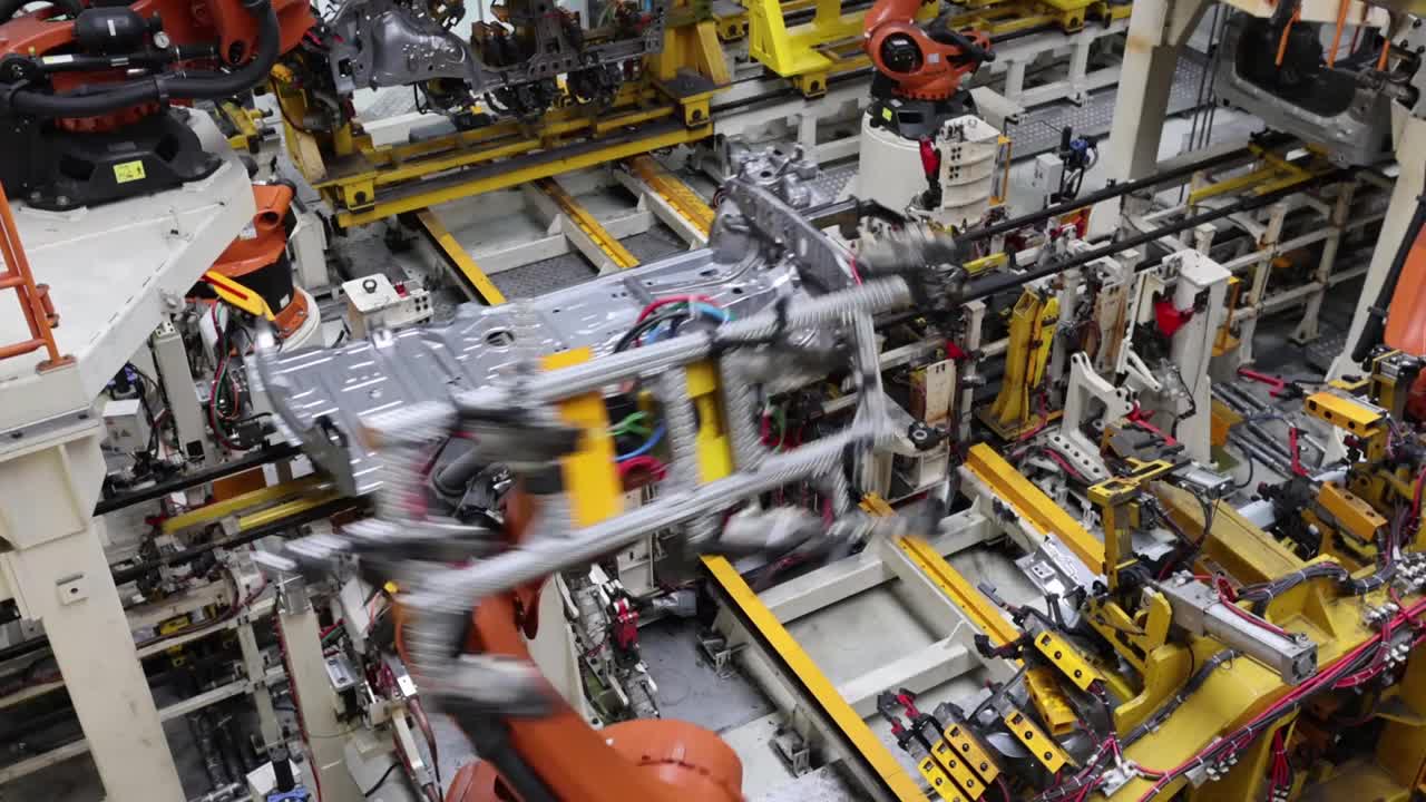在工厂生产电动汽车时，焊接工作由机器人完成视频素材