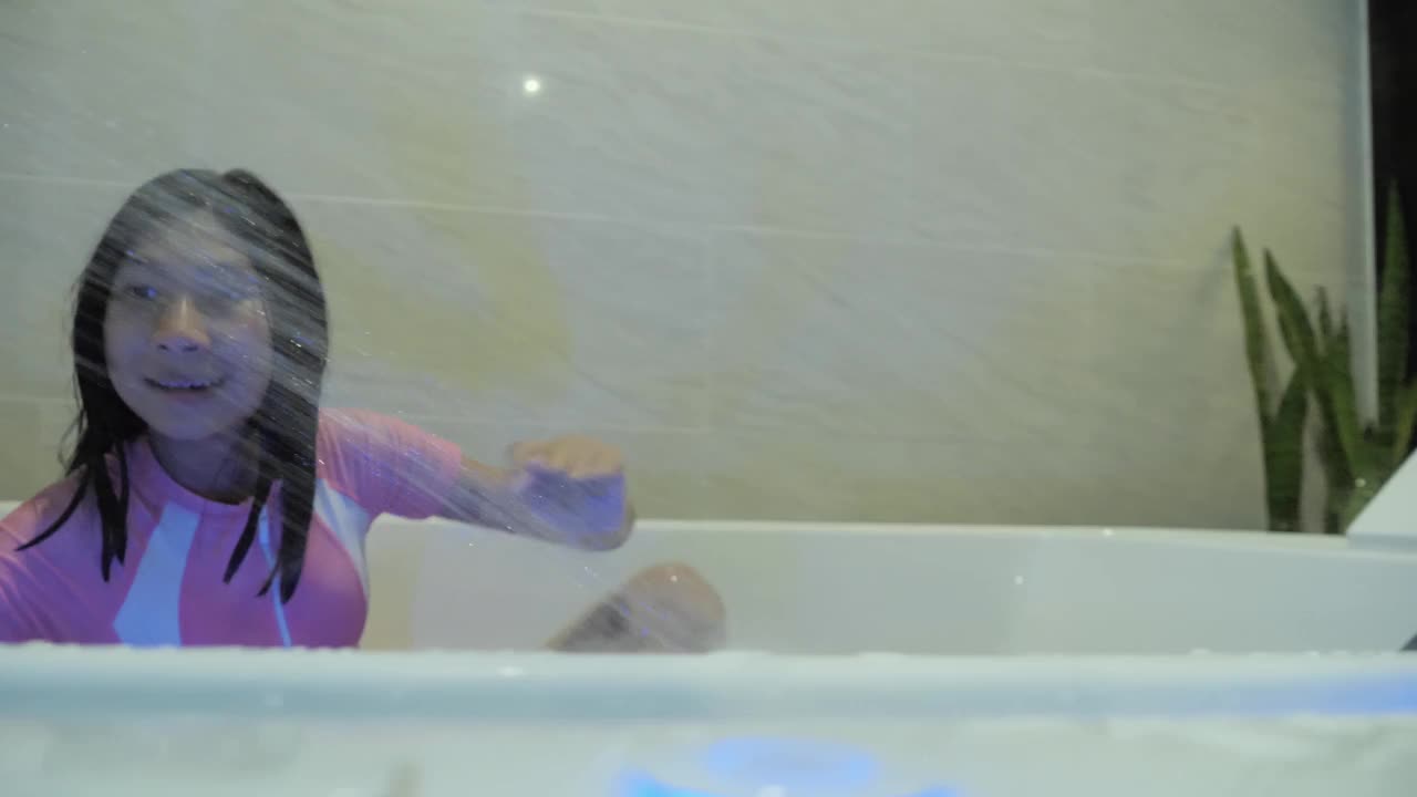 快乐的亚洲女孩在热水浴缸洗澡在她的假期与家人在酒店或度假村，生活方式的概念。视频下载