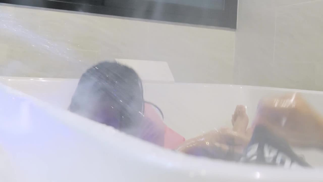 快乐的亚洲孩子们在度假期间一起在酒店房间的热水浴缸中体验新的生活方式，生活理念。视频下载