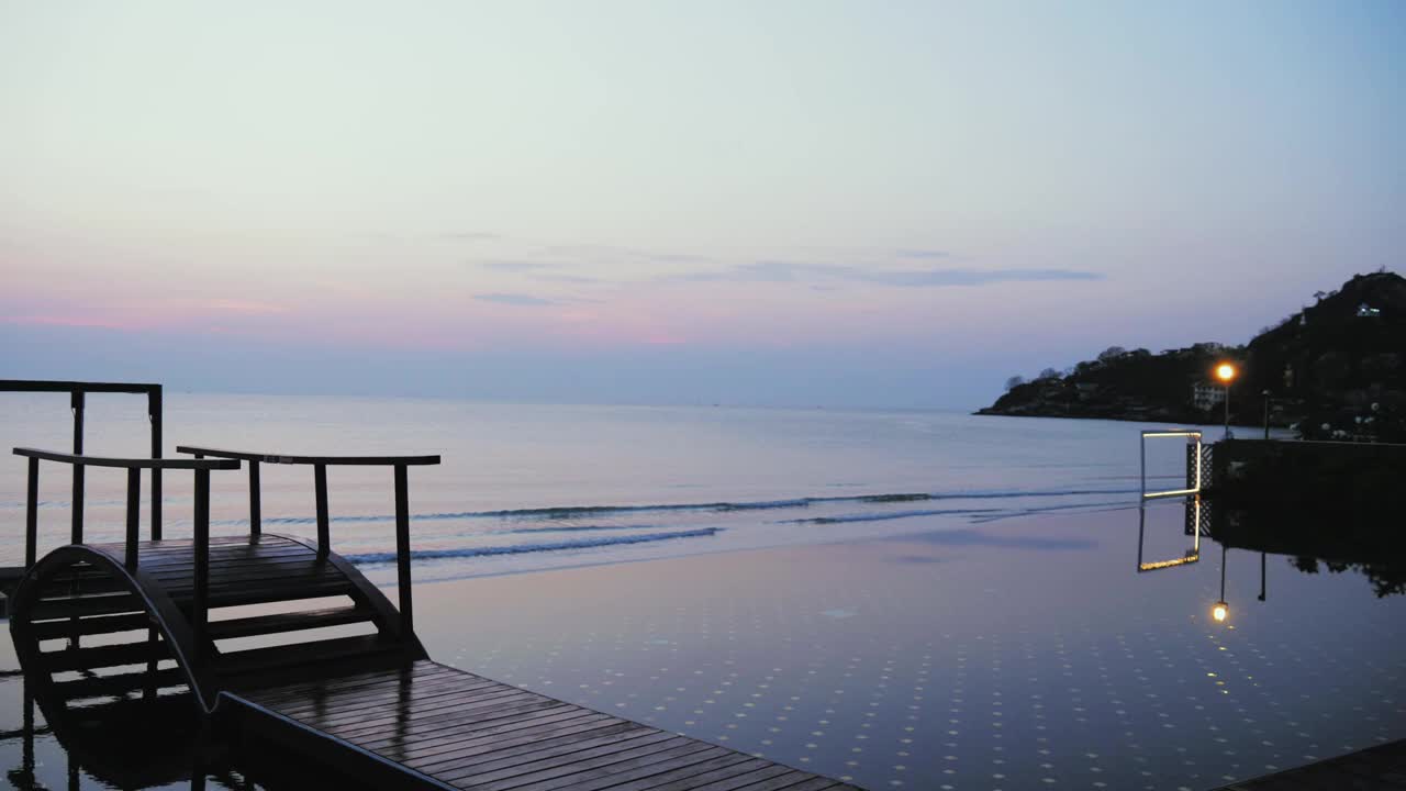 黄昏背景的游泳池附近的日间床，生活理念。视频下载