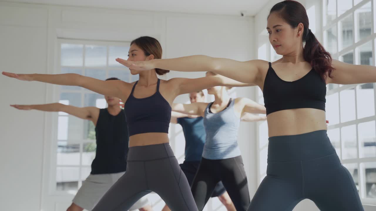 一群不同的人在一起做健身锻炼，学习和练习瑜伽课视频素材