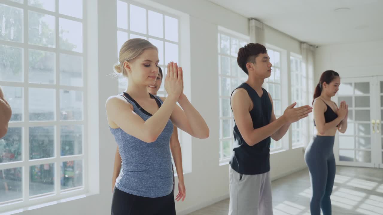 多元化的年轻运动男人和女人学习和训练瑜伽，同时由亚洲女教练指导视频素材