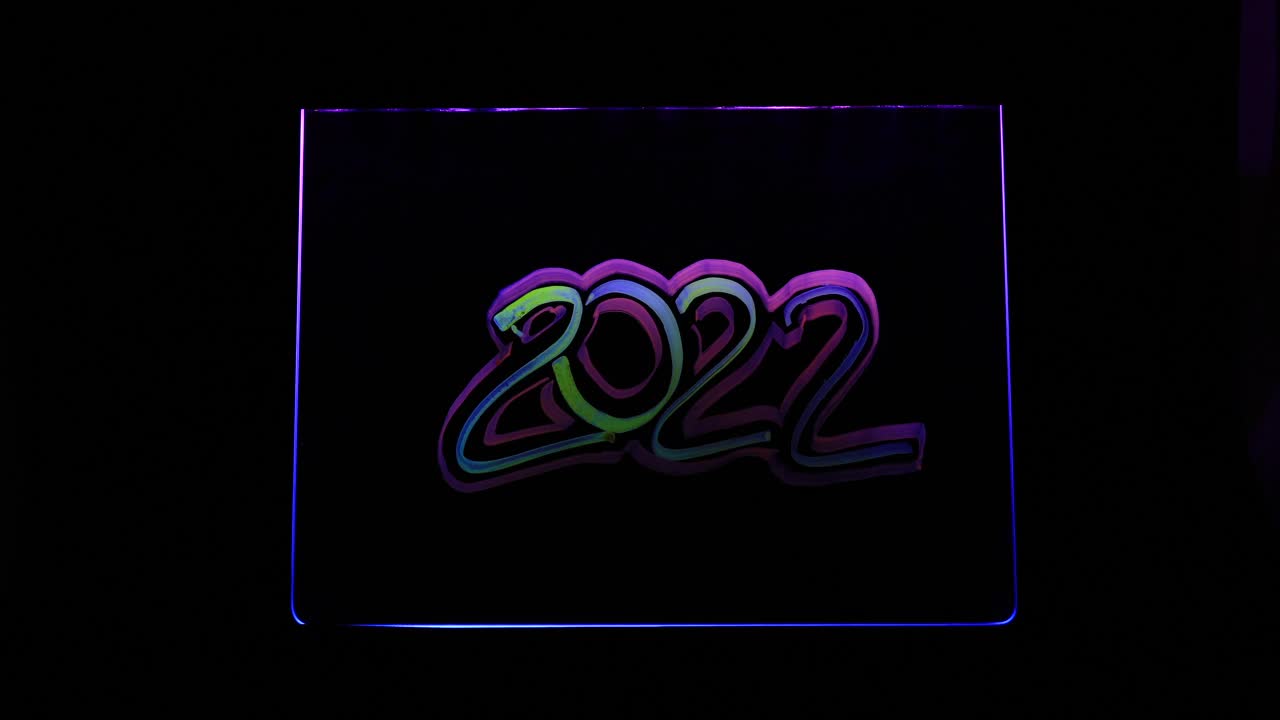 用记号笔在玻璃上用霓虹灯照明的双边框平滑发光字2022新年快乐视频下载