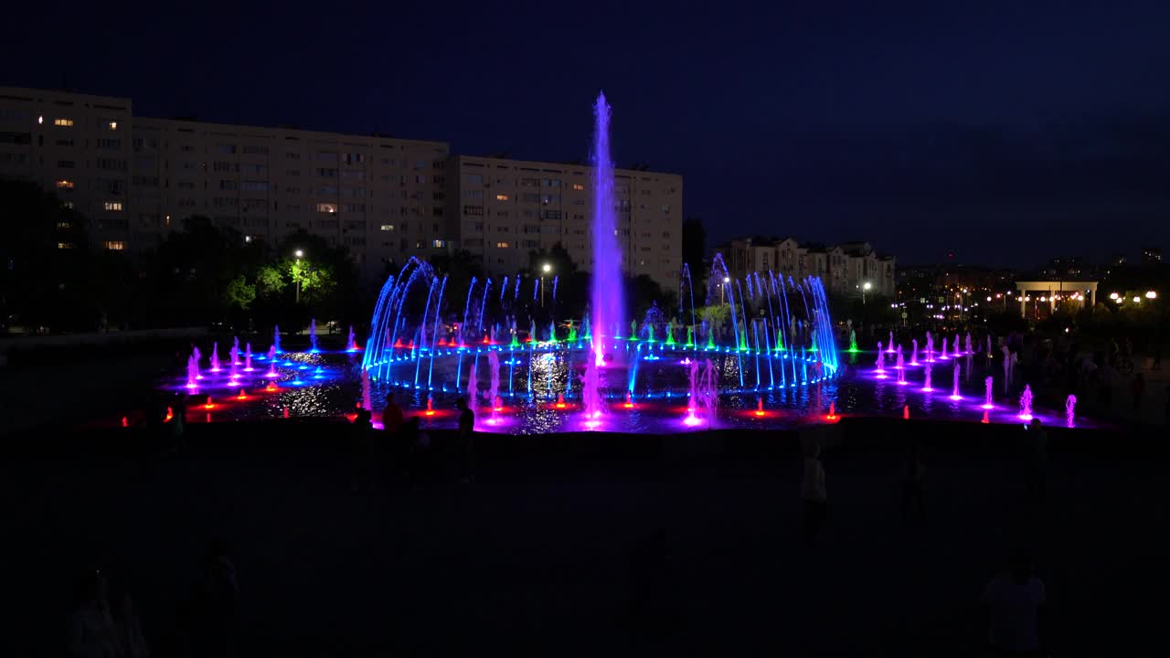 夜晚，五彩缤纷的喷泉闪闪发光视频素材