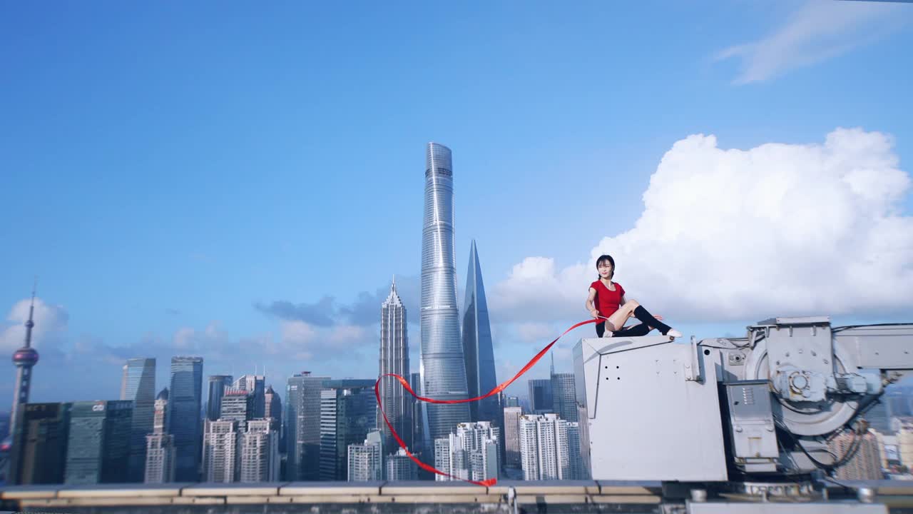 一名美丽的亚洲女子在蓝天下舞动着红丝带。视频素材