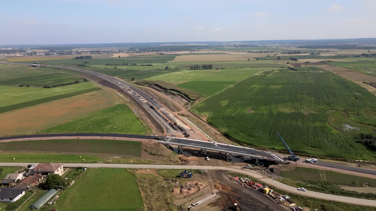 从上面往下看，在欧洲的田野和村庄之间正在建设的高速公路视频下载