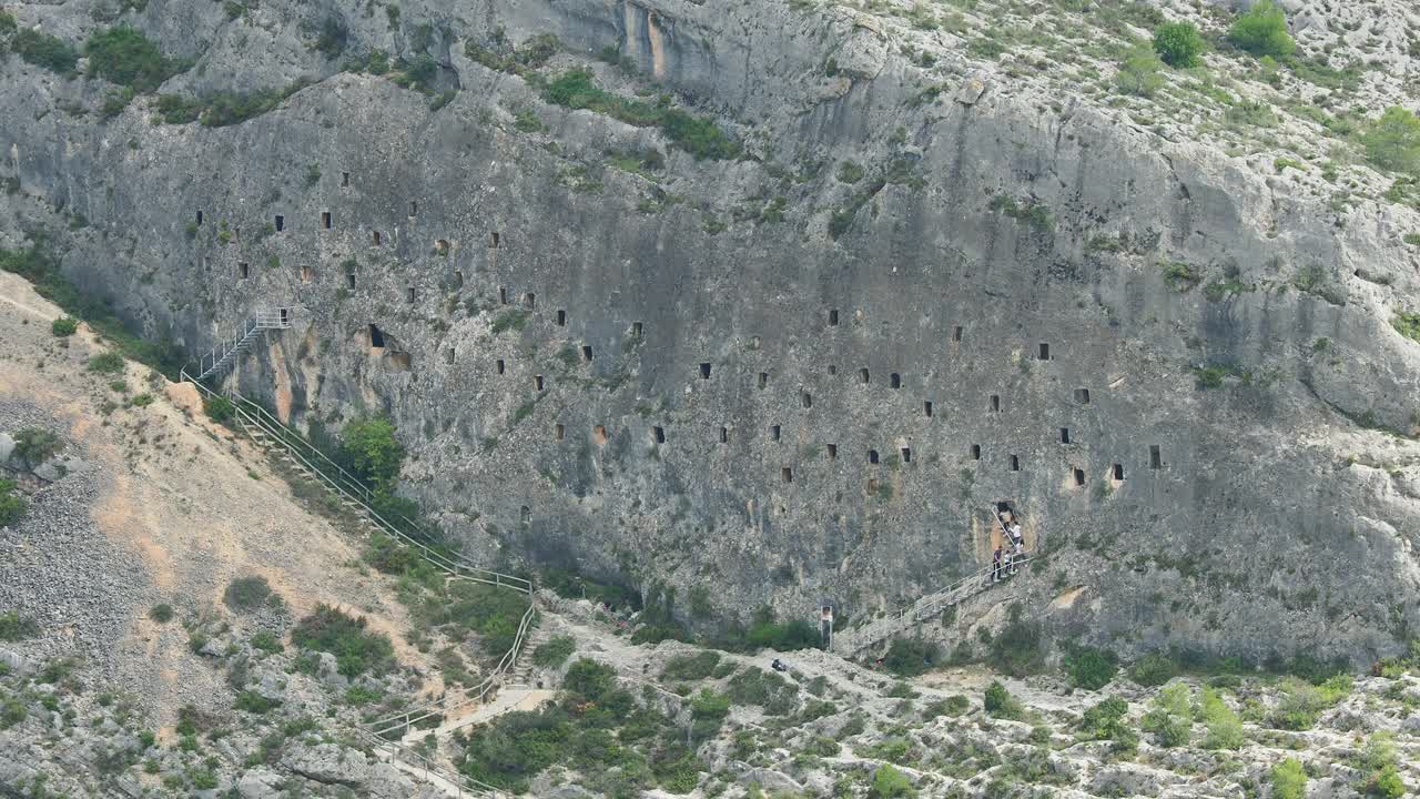 在西班牙博cairent的Cuevas de los Moros，一群游客正在参观挖掘在岩石内部的洞穴(摩尔洞穴)。视频下载