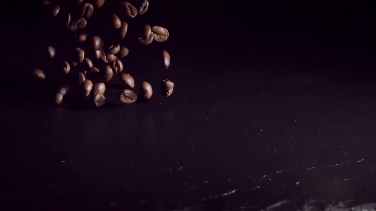以1000帧/秒的速度，咖啡豆落在黑暗的石头上。超级慢动作视频素材
