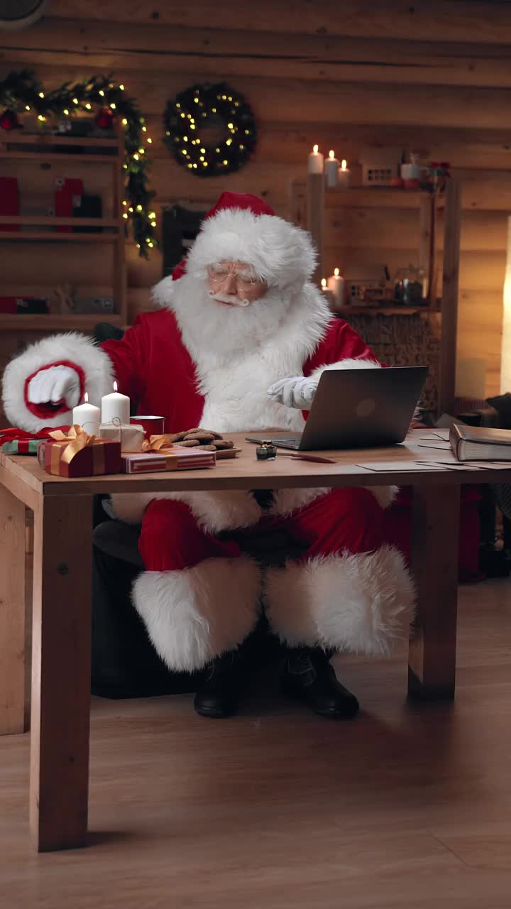 圣诞老人打开装有信件的信封，在他的笔记本电脑上做上记号视频下载