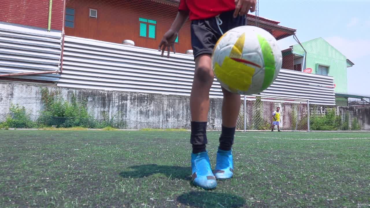 男孩的腿在球场上弹跳球慢动作视频下载