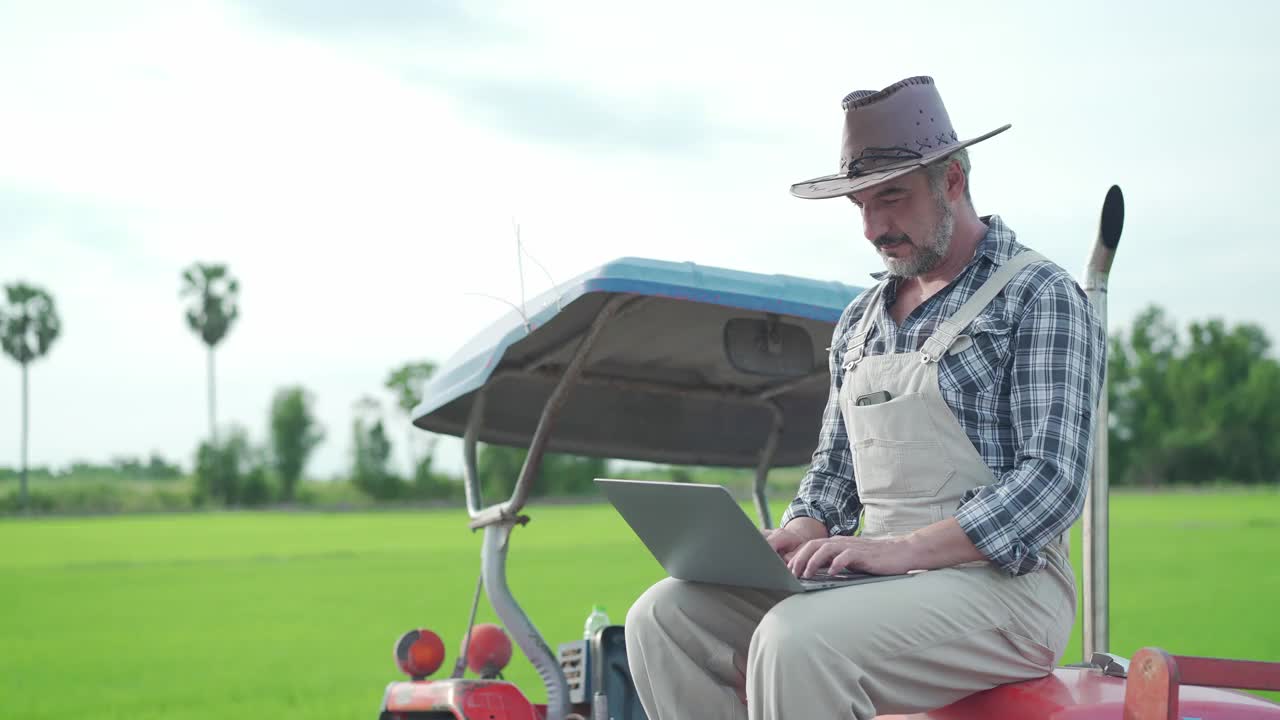 农夫坐在拖拉机上讲电话视频素材