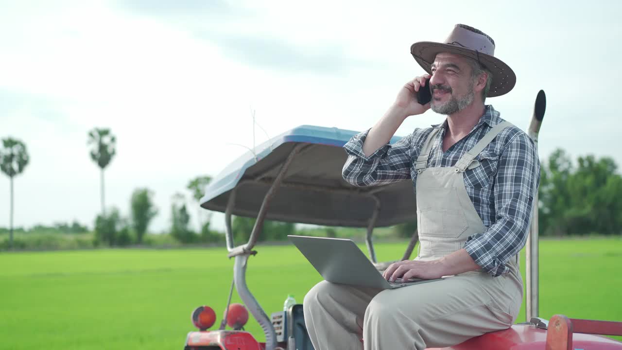 农夫坐在拖拉机上讲电话视频素材