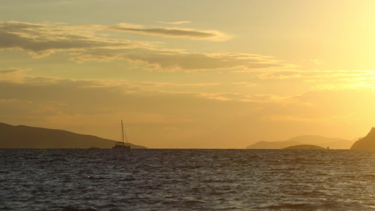 一艘满帆远航的晚霞幻想船在橘黄色的晚霞天空映衬下形成了轮廓视频素材