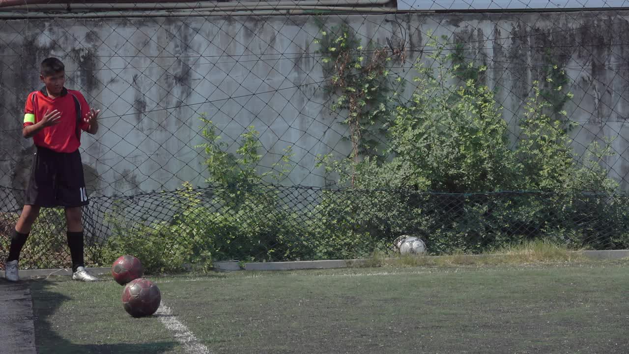 男孩足球运动员在球场上练习慢动作视频素材