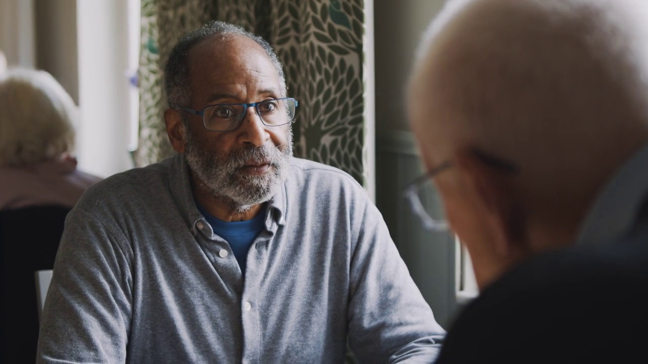 一位老人坐在养老院和他的男性朋友聊天视频素材