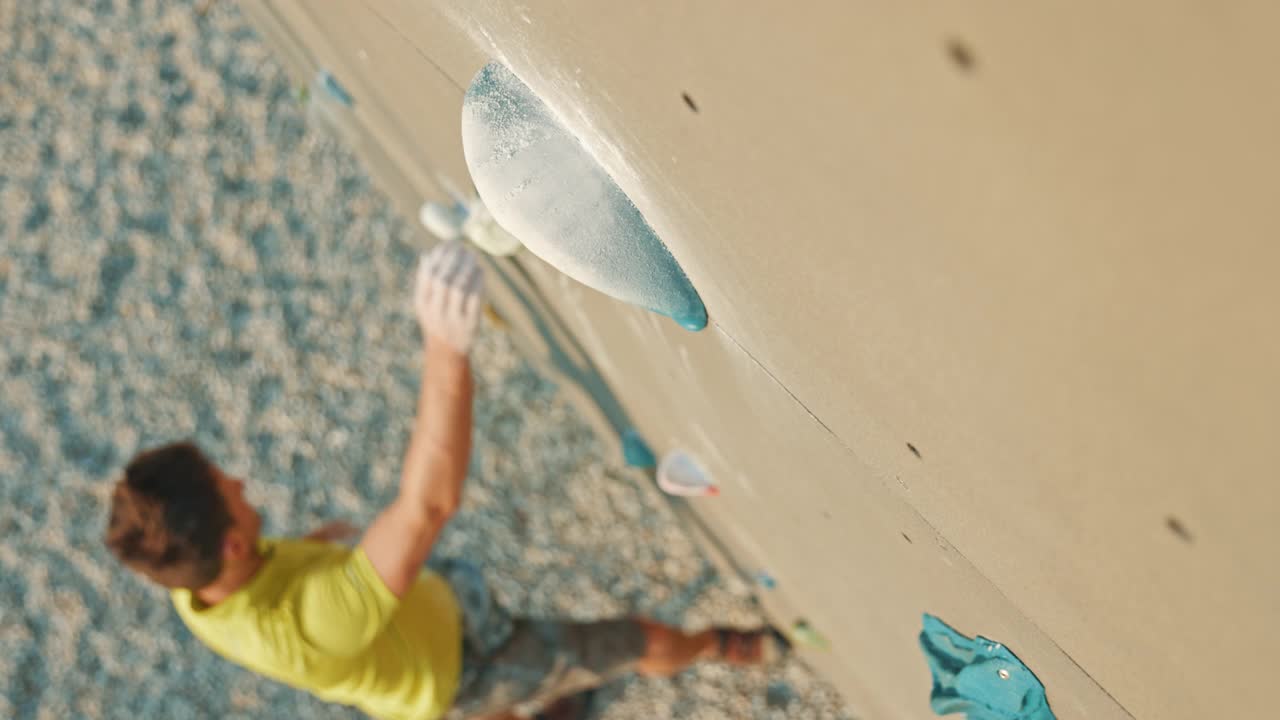 中年男性攀岩者试图抓住人造巨石视频素材