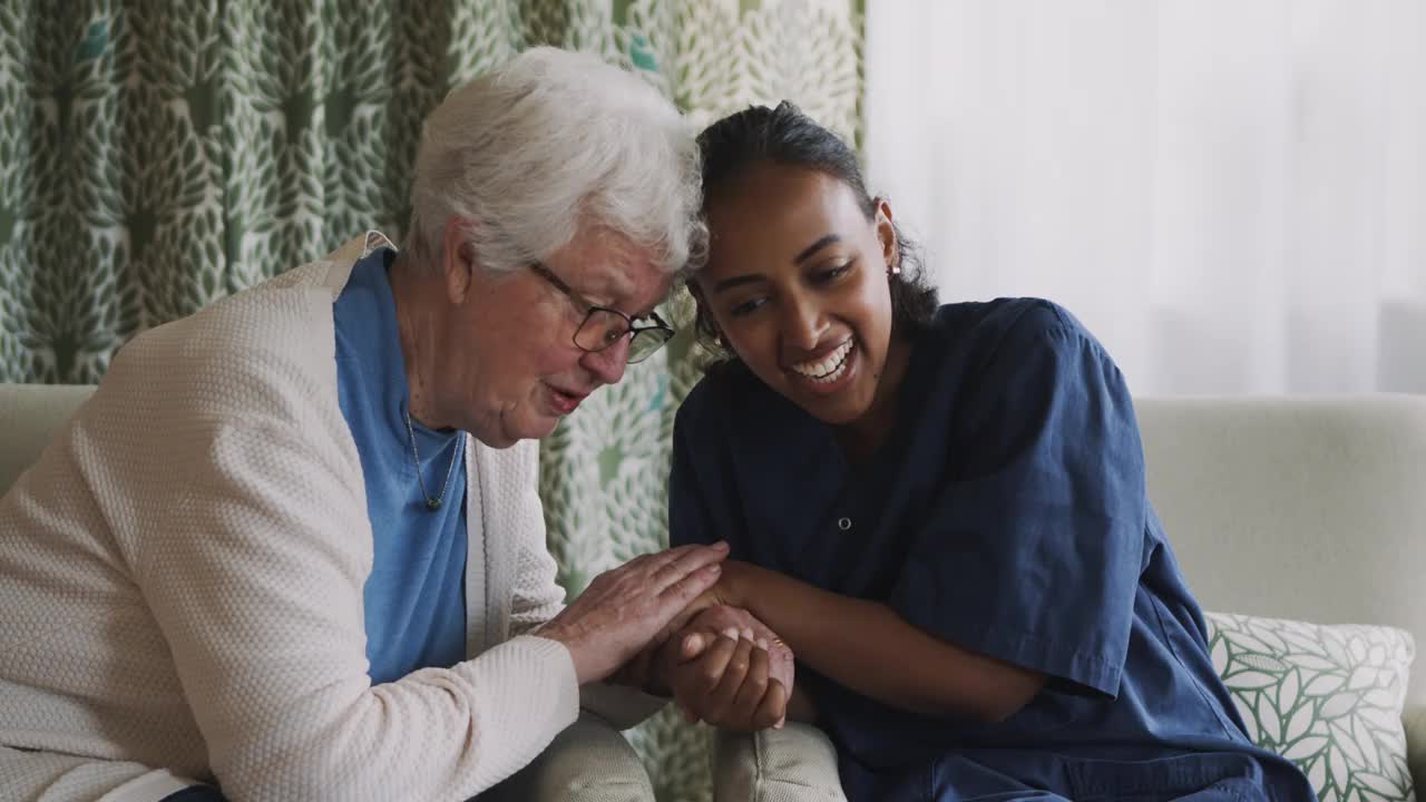 愉快的女护士在客厅里和老妇人聊天视频素材