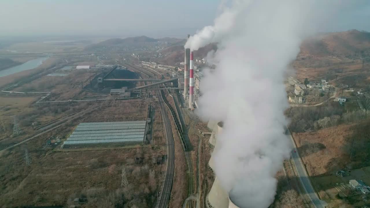 无人机在浓烟中飞行。俯瞰工业区的管道，浓烟滚滚。火力发电厂管道、空气污染。视频素材