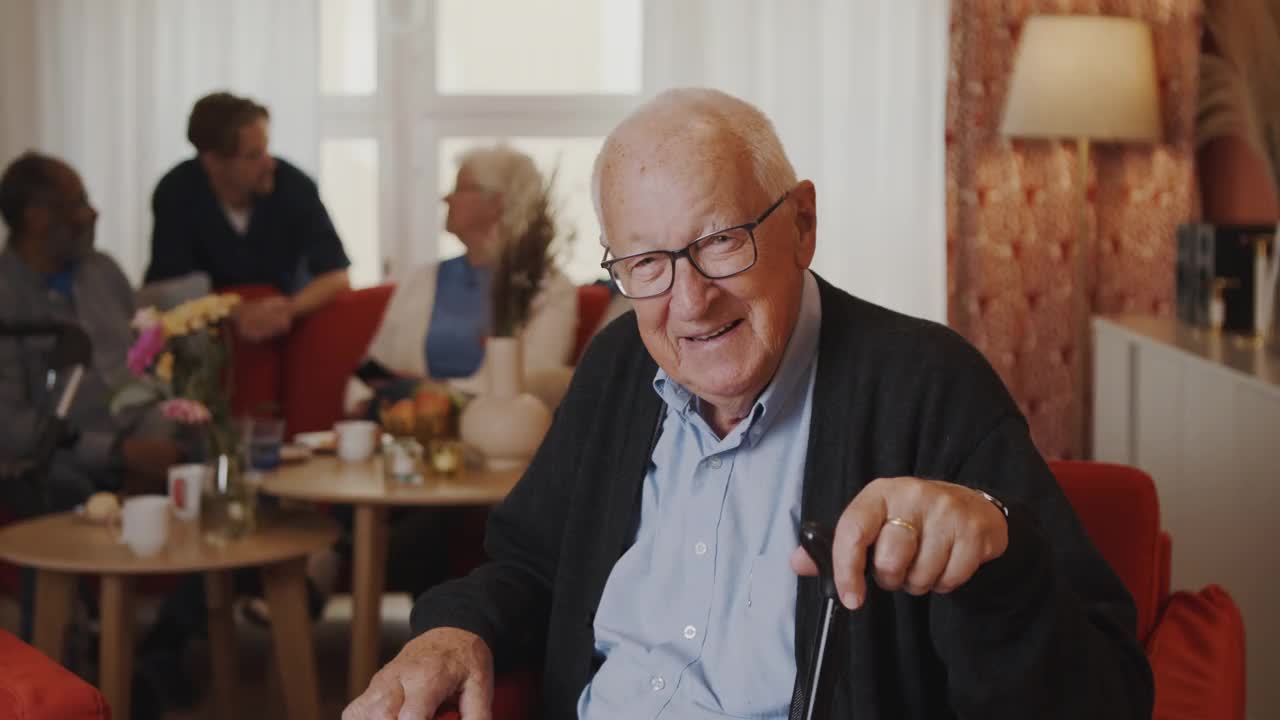 一个快乐的老人坐在养老院的椅子上视频素材