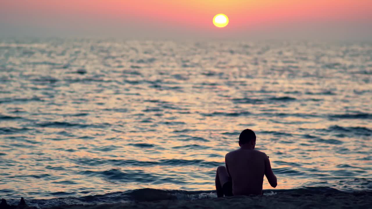 在热带海滩上用手机拍摄令人惊叹的夏日日落、日出照片的剪影视频素材