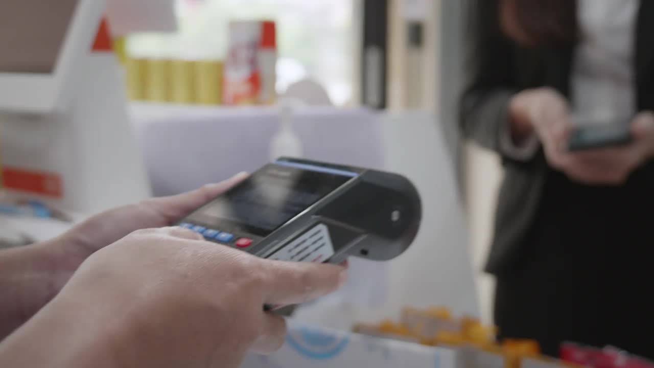 一位女商人通过智能手机付款的手的特写视频下载