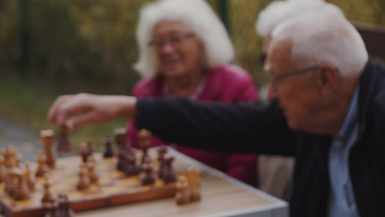 一位老人和女性朋友在餐桌上下棋视频素材