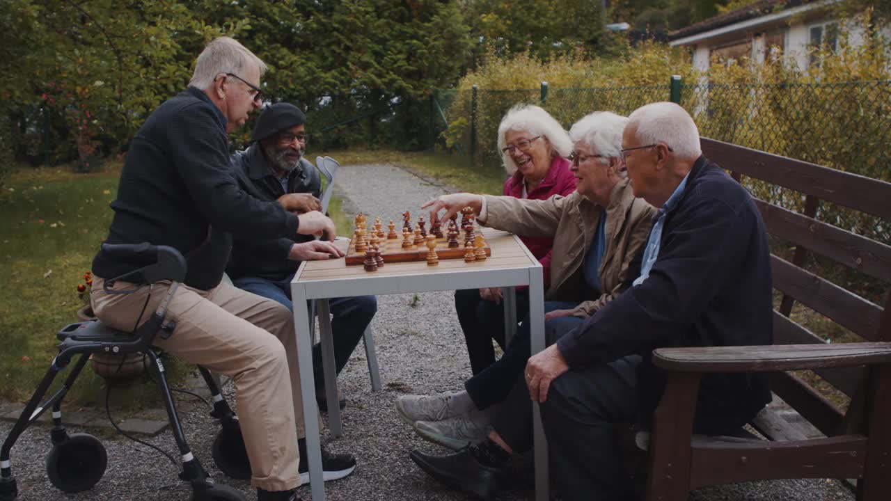 年长的男女朋友在公园的桌子上下棋视频素材