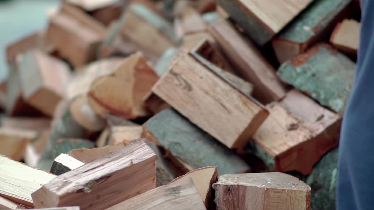 伐木工人用锋利的斧头在森林深处砍树，斧头的细节，木屑在缓慢地飞舞视频素材