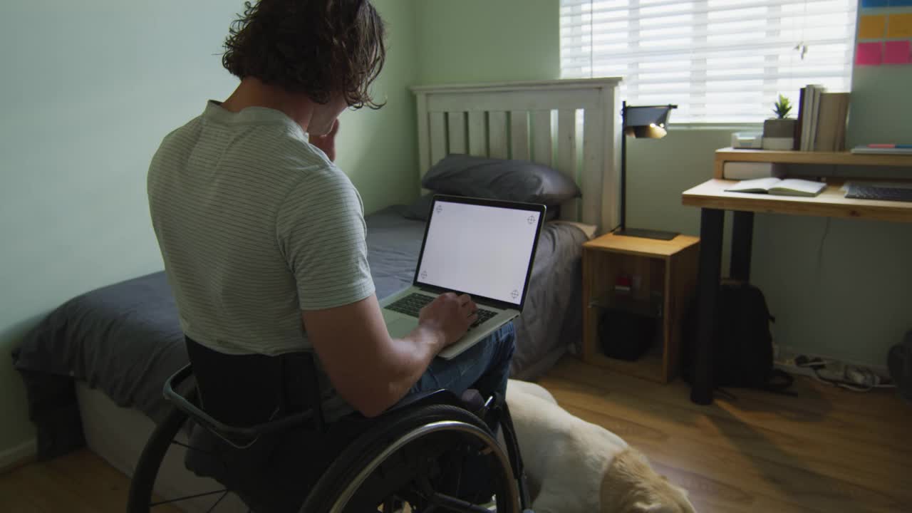 白人残疾人坐在轮椅上使用笔记本电脑在卧室视频下载