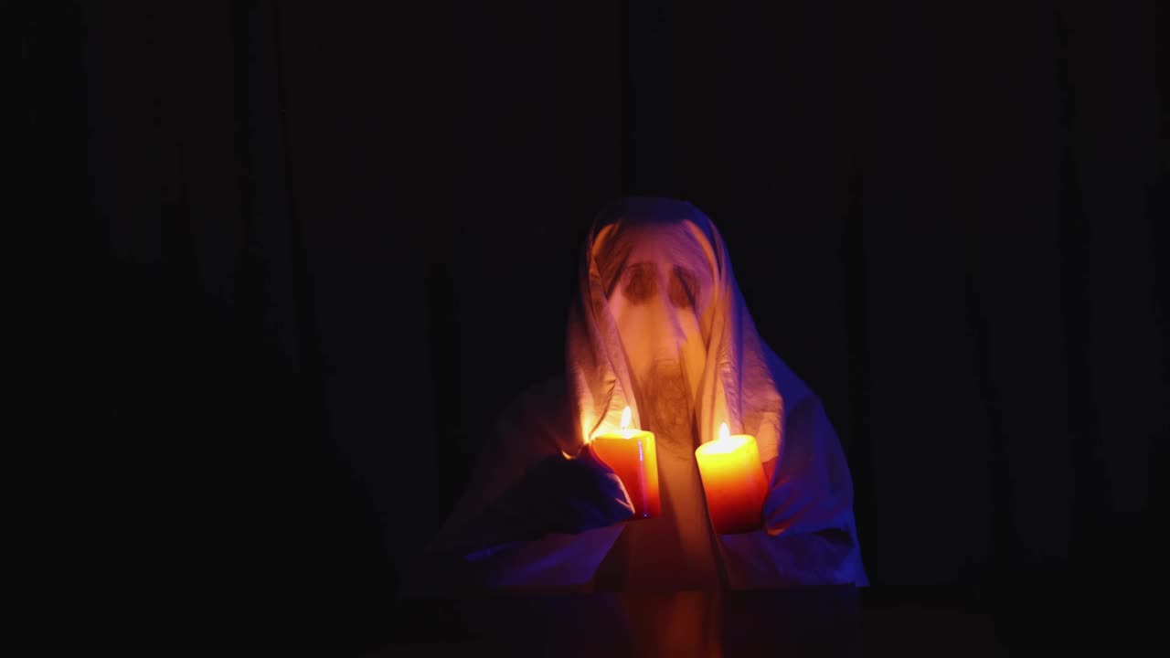 万圣节嘉年华庆祝会:家鬼装扮，展示燃烧的蜡烛视频下载