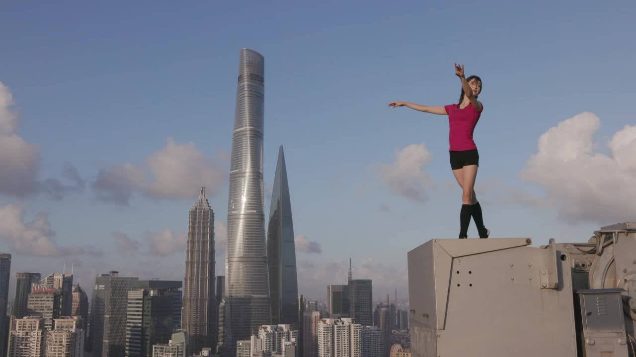 一位年轻的芭蕾舞女舞者在中国上海的楼顶上跳舞视频素材