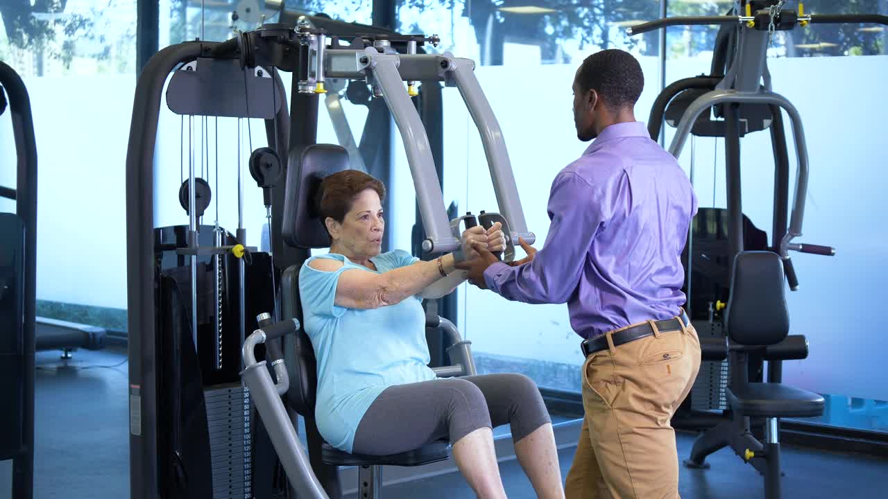 理疗师帮助老年女性锻炼上半身视频素材