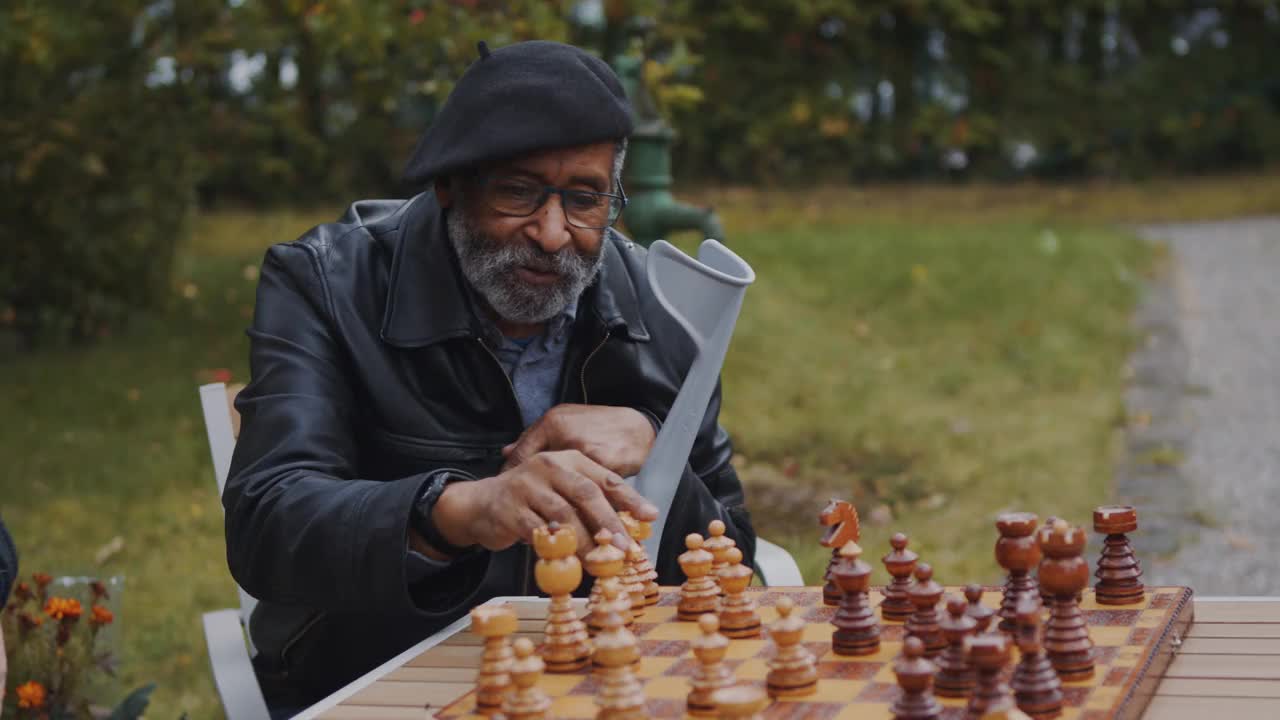 一位老人在公园的餐桌上玩棋盘游戏视频素材