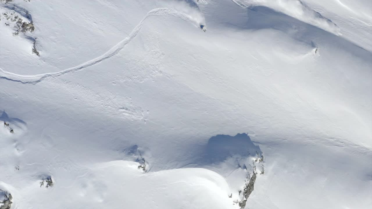 雪崩无人机拍摄的一名滑雪者从雪崩中滑下山坡。视频下载