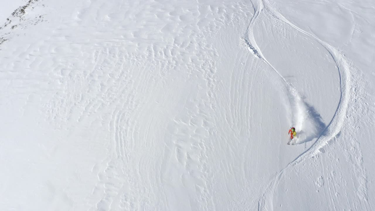 空中无人机拍摄的滑雪者在积雪覆盖的山上滑雪。视频素材