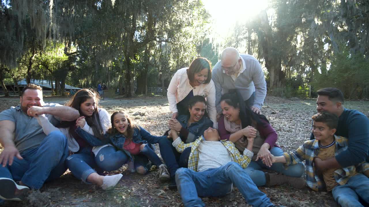 几代西班牙裔家庭在公园里，坐在地上视频下载
