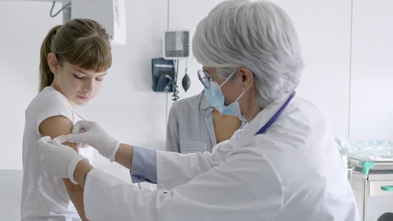 医生给医院里的女孩注射新冠疫苗视频素材