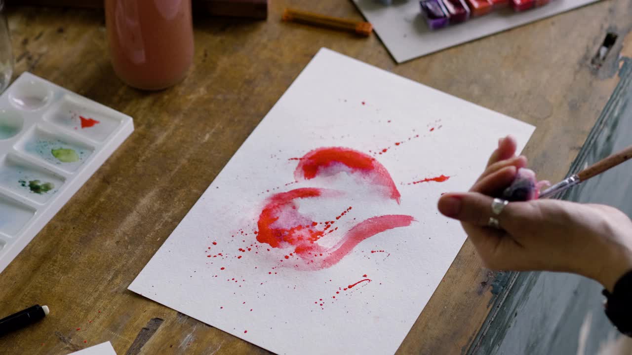 女艺术家的手在水彩中画一颗红心的特写镜头。4 k视频下载